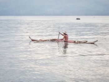 Man in sea against sky