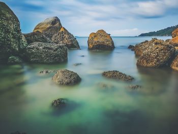 View of rocks in sea against sky