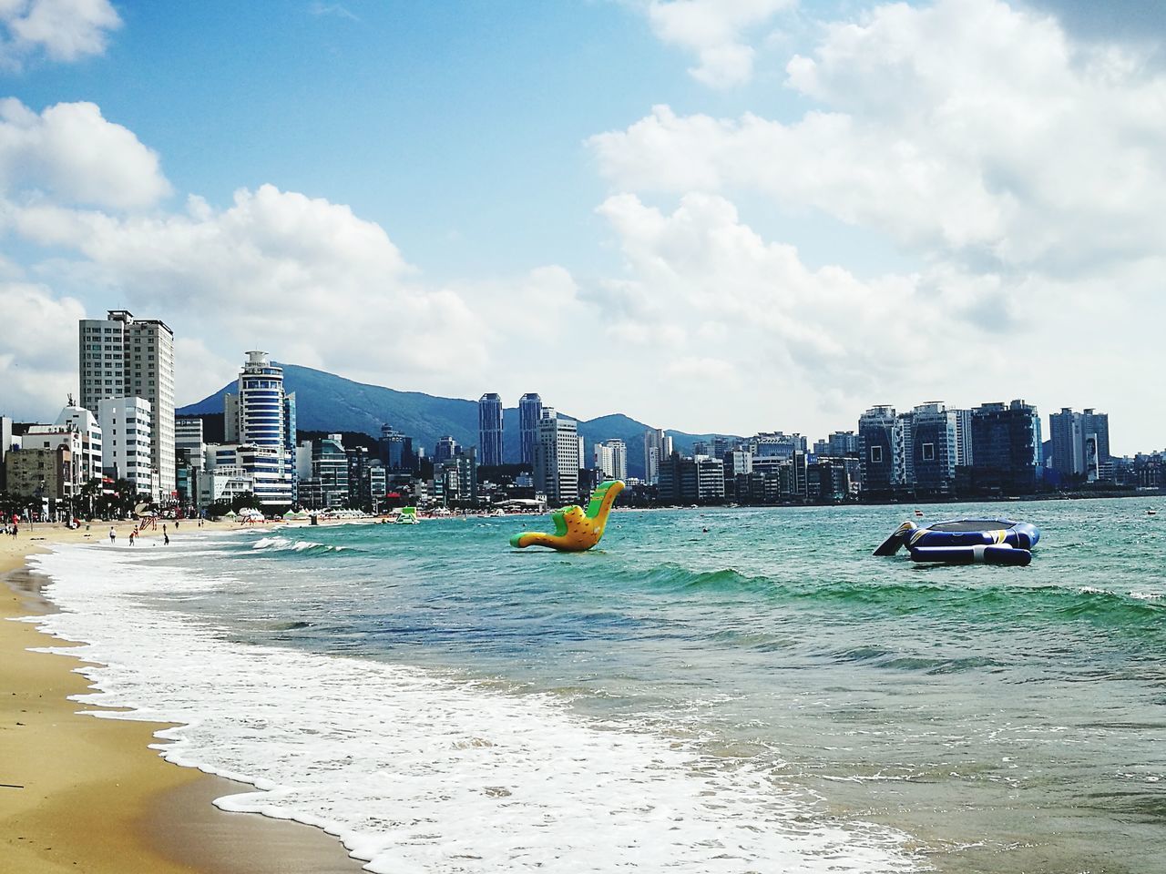 architecture, building exterior, city, sea, built structure, skyscraper, water, cloud - sky, sky, beach, cityscape, day, outdoors, no people, urban skyline, travel destinations, sand, modern, nature