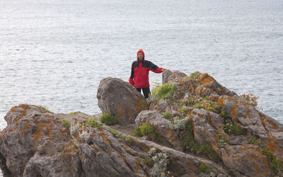 Man standing on cliff by sea