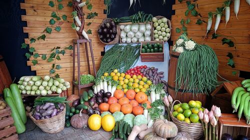 Variety of fresh harvested vegetables and fruits for sale at market stall