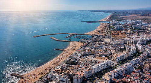 High angle view of townscape by sea against sky