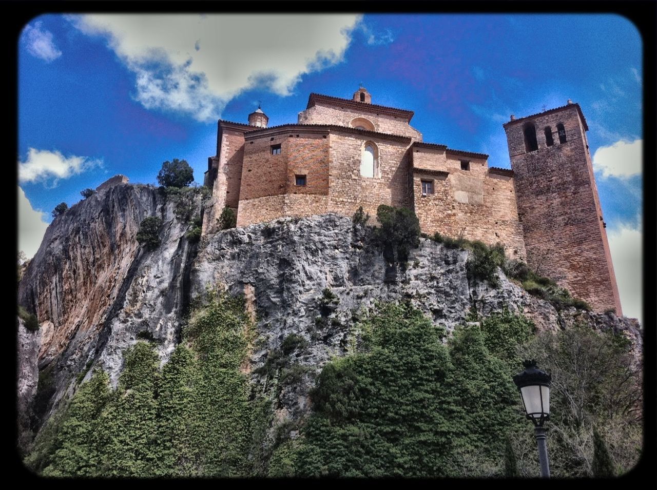 architecture, built structure, transfer print, sky, low angle view, building exterior, history, auto post production filter, blue, stone wall, old, the past, cloud, cloud - sky, old ruin, castle, tower, sunlight, day, outdoors