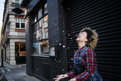 Side view of young woman looking away in city