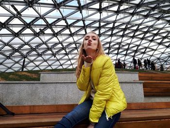 Full length of a young woman sitting outdoors