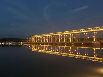 Illuminated bridge over river at night