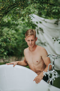 Portrait of shirtless young man in water