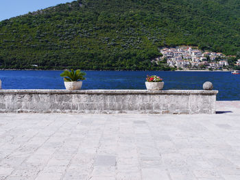 View of retaining wall by sea against mountain