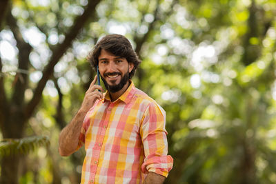 Young man at park on a beautiful sunny day with mobile phone.  working  leisure. green and nature 