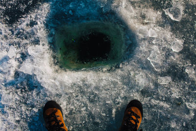 Low section of man standing by water