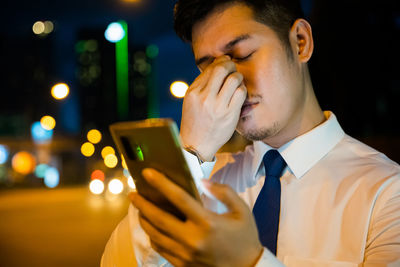 Young man using mobile phone at night