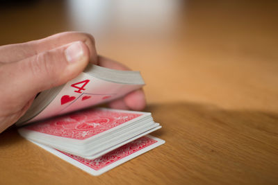 Close-up of hand playing cards on table