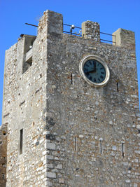 Low angle view of old building against clear blue sky