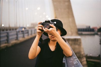 Midsection of man photographing in city