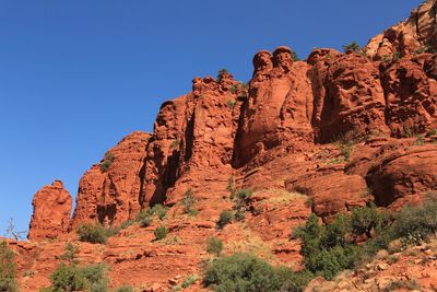 Low angle view of rock formation against clear blue sky