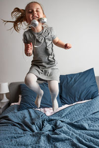 Little girl singing holding headphones cord imitating herself a real singer. child having fun