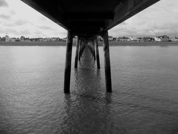 Bridge over river against sky in city