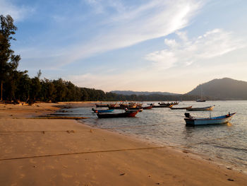 Boats moored on sea against sky