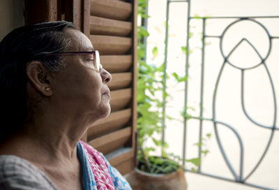 An aged bengali woman casually looking out of window