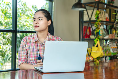 Businesswoman using laptop while sitting on table