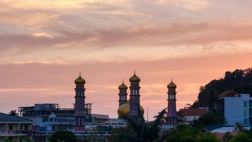 Buildings in city against sky during sunset