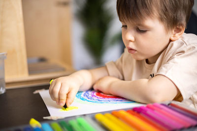 Close-up of boy drawing on book