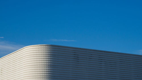 Low angle view of modern building against clear blue sky