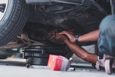 Midsection of man repairing car