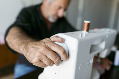 Tailor adjusting sewing machine while working in studio