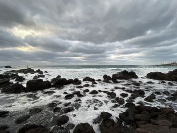 Scenic view of rocks on sea against sky