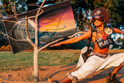 Midsection of woman on field against trees