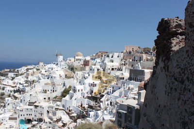 Buildings in town against clear blue sky