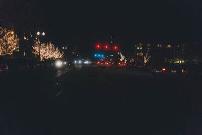 Illuminated city against clear sky at night