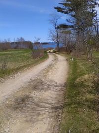 Road amidst field against sky