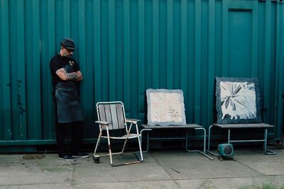 Man standing on chair outdoors