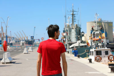 Rear view of man standing in city against clear sky