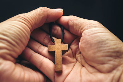 Close-up of human hand holding cross