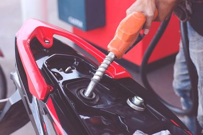 Midsection of man refueling motorcycle