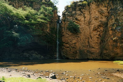 Scenic view of lake by rock formation