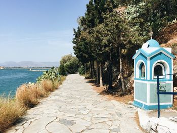 Footpath by sea against sky