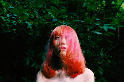 Portrait of woman standing against plants