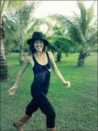 Portrait of smiling young woman wearing hat on field