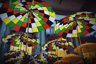 Low angle view of multi colored umbrellas hanging indoors