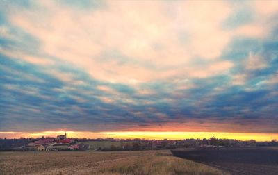 Scenic view of dramatic sky over landscape during sunset