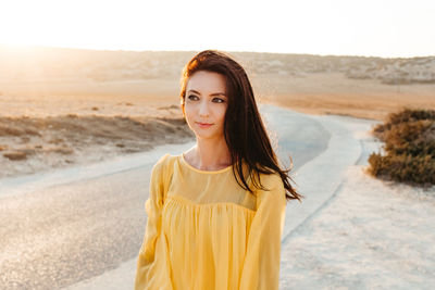 Portrait of young woman standing on land