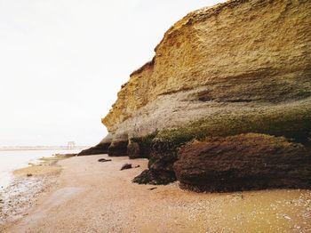 View of rocky beach against clear sky