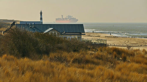 Buildings by sea against sky