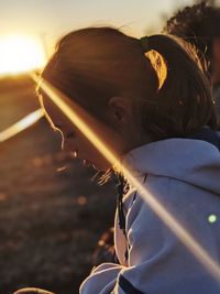 Close-up portrait of woman against sky during sunset