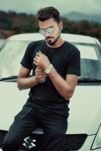 Young man wearing sunglasses while sitting in car