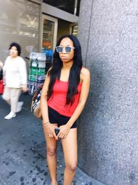 Young woman standing by railing